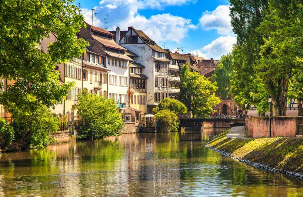 Strasbourg, water canal in Petite France area. Half timbered houses and trees in Grand Ile. Alsace, France. Unesco Site.